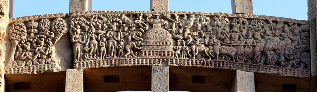 A long carved stone lintel crowded with figures, horses and a stupa.