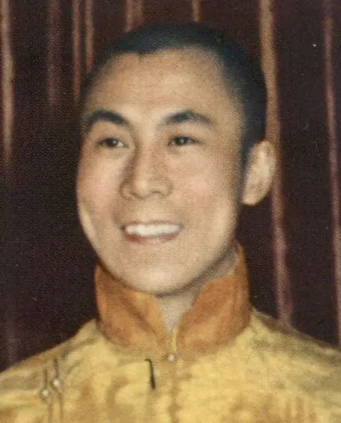 A colour photograph of a smiling young man in a yellow robe.