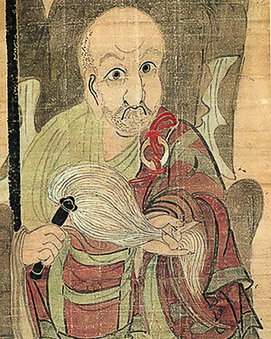 A painting of a wide-eyed old monk in a red robe holding a whisk.