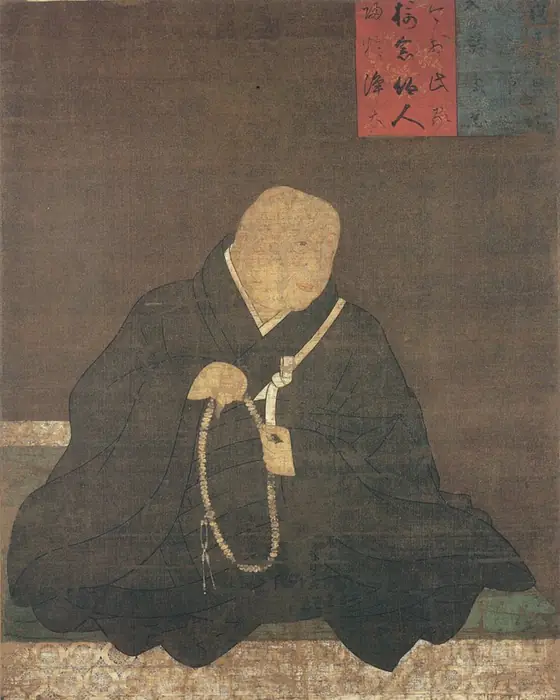 A painting of an elderly monk in dark robes, seated with prayer beads.