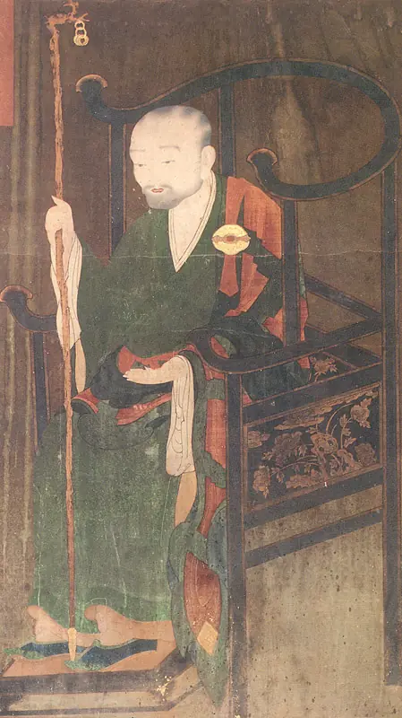 A painting of a seated monk in a green robe holding a staff.