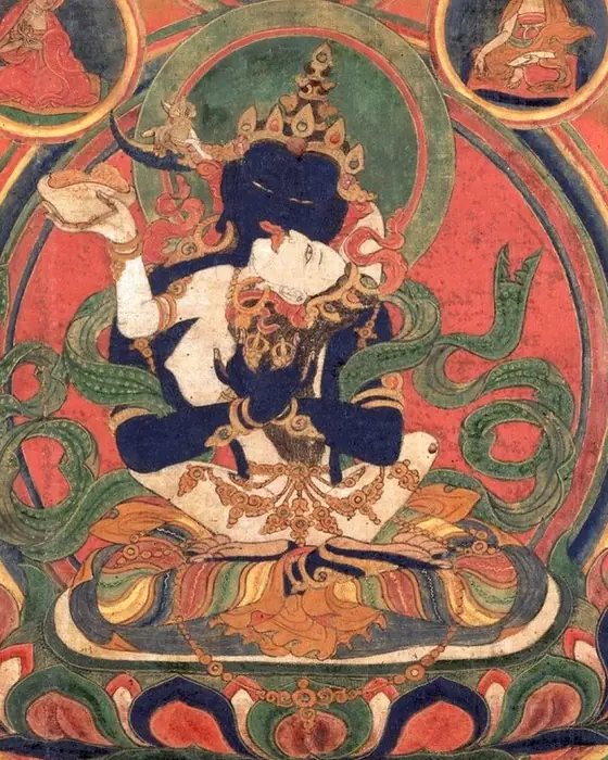 The centre of a Tibetan painting: two embracing deity-like figures on a lotus, within circles of red and gold.