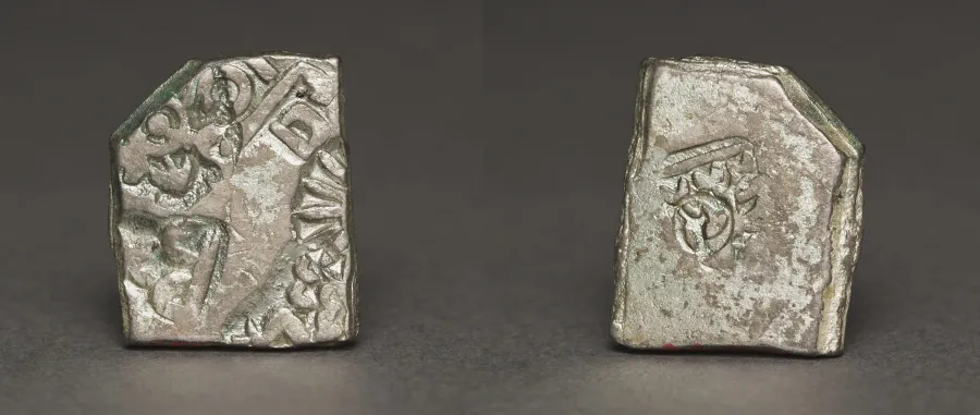 Two small, irregular silver coins stamped with worn symbols.